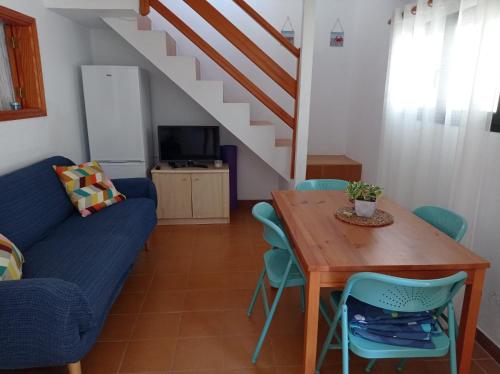 sala de estar con mesa y sofá azul en Casa en la playa, Aldea Coast, en San Nicolás