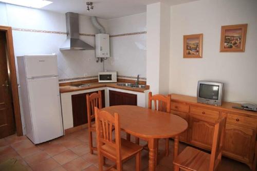 cocina con mesa, sillas y nevera en Apartamento Cadiz Bajo, en Conil de la Frontera