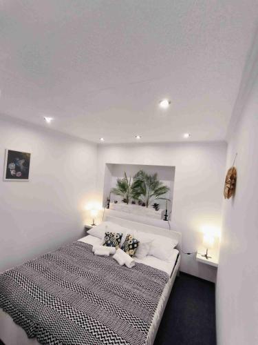 a bedroom with a large bed with white walls at Baky House in Balatonlelle