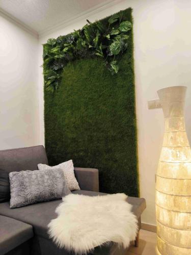 a living room with a couch and a green wall at Baky House in Balatonlelle
