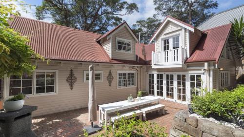 CopacabanaCoastal Cottage with Pool at Copacabana的一间门前有长凳的房子