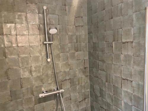 een douche in een badkamer met een betegelde muur bij Brour&Bos in Laren