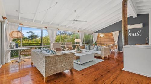 a living room with a couch and a table at Sublime Beach Getaway, Spacious Balcony with BBQ in Copacabana