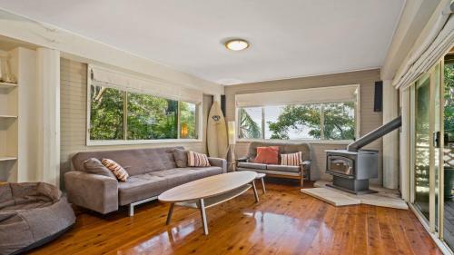 a living room with a couch and a stove at Sublime Beach Getaway, Spacious Balcony with BBQ in Copacabana