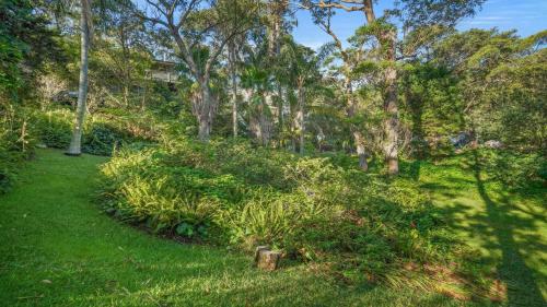 a path through a park with trees and grass at Sublime Beach Getaway, Spacious Balcony with BBQ in Copacabana