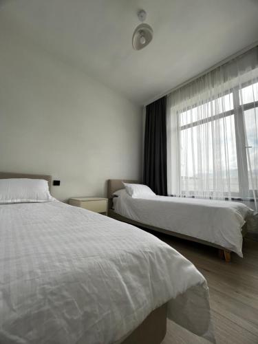 Chok-Tal的住宿－Palm_beach，酒店客房设有两张床和窗户。