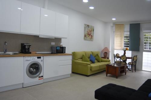 a kitchen and a living room with a washing machine at aparment la Elipa in Madrid