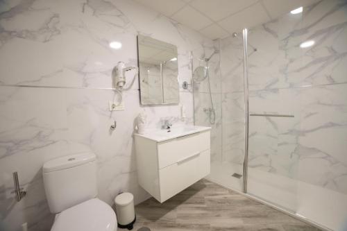 a white bathroom with a toilet and a shower at Hostal Altea Karma in Altea