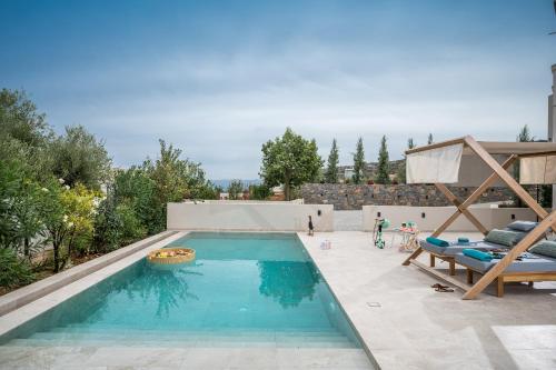 a swimming pool in the middle of a backyard at Grace Villas Collection in Hersonissos