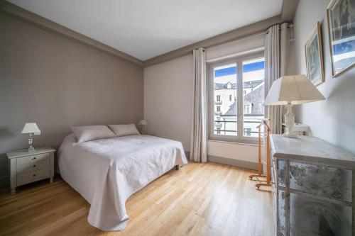 a bedroom with a bed and a large window at L'anthracite - Proche Opéra & Centre-ville in Vichy