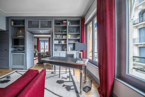 Cette chambre comprend un bureau et un rideau rouge. dans l'établissement L'ANTHRACITE - Proche Opéra & Centre-ville, à Vichy