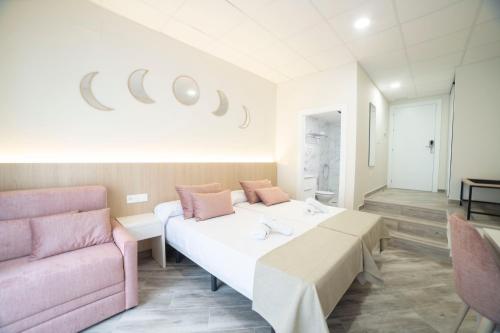 a room with two beds and a pink couch at Hostal Altea Karma in Altea