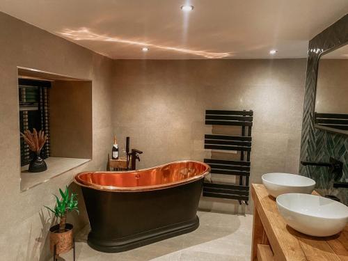 a bath tub in a bathroom with a sink and a toilet at Bulls Head - Holymoorside in Chesterfield