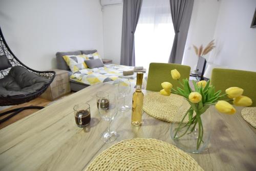 a dining room table with wine glasses and flowers on it at Studio 13 in Kragujevac