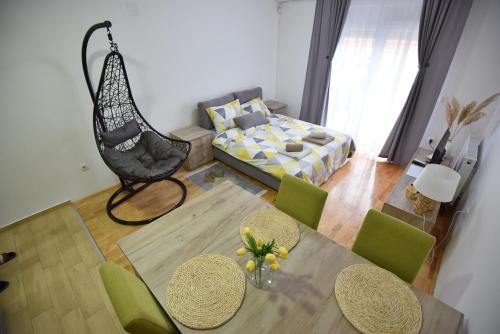 - un salon avec une table, des chaises et un lit dans l'établissement Studio 13, à Kragujevac
