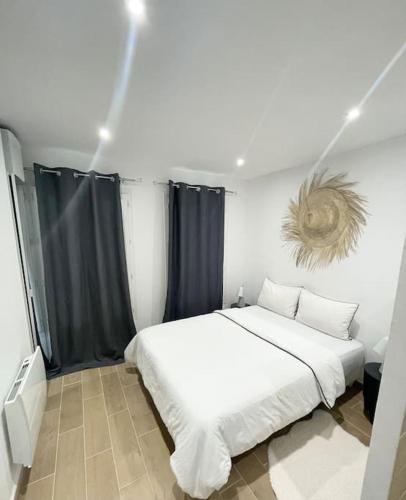 a bedroom with a large white bed with black curtains at Appartement Cosy Aix en Provence in Aix-en-Provence