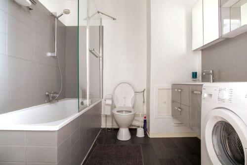 une salle de bain avec toilettes et baignoire et une machine à laver dans l'établissement Obernai - Studio agréable avec balcon - Proche gare, à Strasbourg