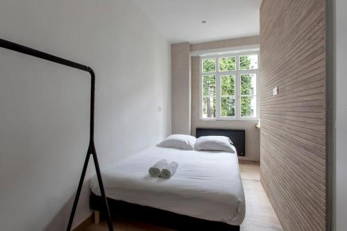 une chambre avec un lit blanc avec une fenêtre dans l'établissement Le Carré D'or - Près de la place Gutenberg, à Strasbourg