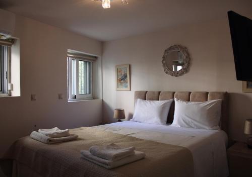 a bedroom with a bed with two towels on it at The Ellinikon - Metro Apartment in Athens