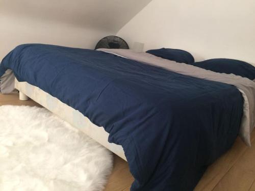Una cama con una manta azul encima. en Ty Cocoon, maisonnette à Arradon !, en Arradon