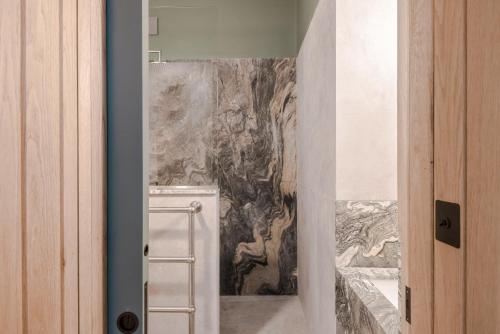 een badkamer met een schilderij aan de muur bij Casa Peppino - Soho - by Frankie Says in Londen
