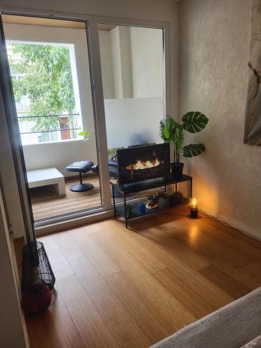 een woonkamer met een open haard en een groot raam bij Cosy in Antwerpen