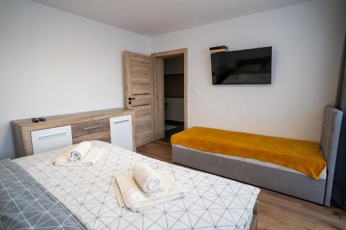 niewielka sypialnia z 2 łóżkami i telewizorem w obiekcie Apartmany ROSTER w Liptowskim Mikulaszu