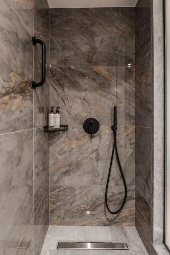 a shower with a glass door in a bathroom at Magnes Hotel in Volos