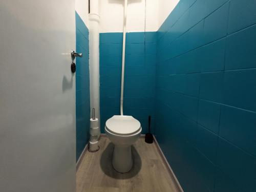 een badkamer met een toilet in een blauwe muur bij Fantastic - NS54 Pokój B in Warschau