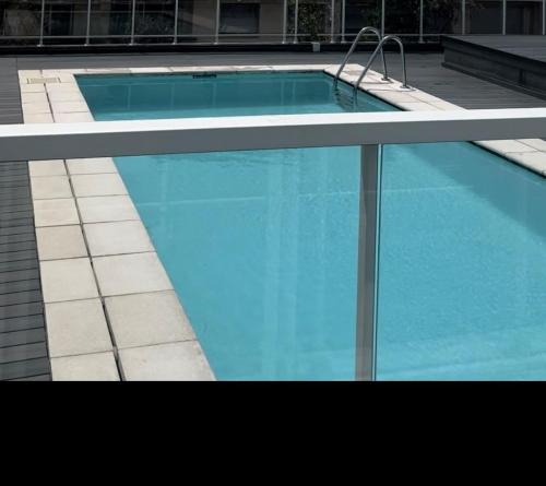 une piscine avec de l'eau bleue dans un immeuble dans l'établissement Studio, à Nice