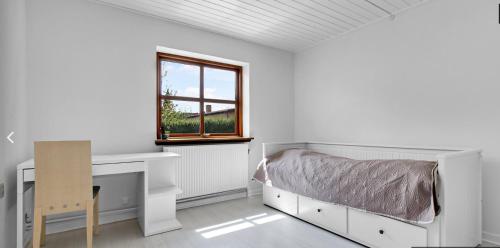1 dormitorio con cama, escritorio y ventana en 4 bedroom 200m2 luxury house with garden in Horsens, en Horsens