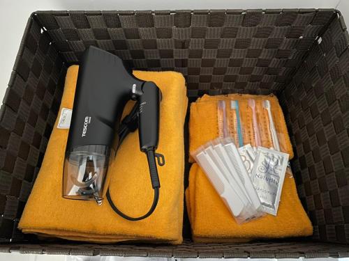a hamper with a hair dryer on yellow towels at IshiuchiBASE in Minami Uonuma