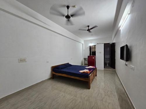 a bedroom with a bed and a ceiling fan at The Urban Escape in Udupi