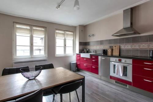 une cuisine avec une table en bois et des placards rouges dans l'établissement Tonneliers, à Strasbourg