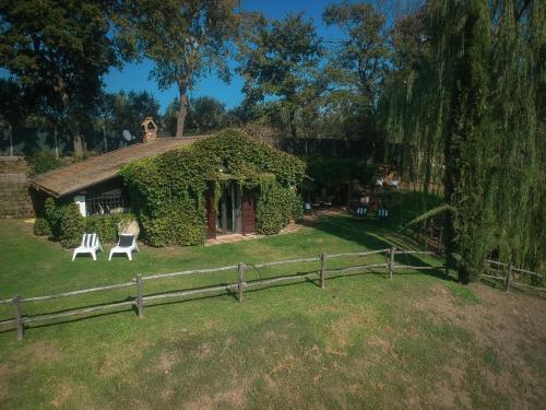 a house with two chairs in front of it at Casale Delle Papere With Private Pool Near Rome in Nepi