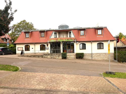 ein Gebäude mit rotem Dach auf einer Straße in der Unterkunft Hotel Alte Apotheke in Bad Dürrenberg