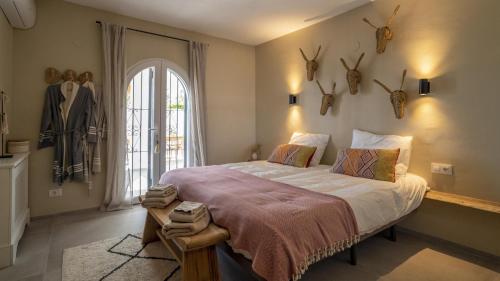 a bedroom with a large bed with antlers on the wall at Casa Peponi - By Almarina Villas in Jávea