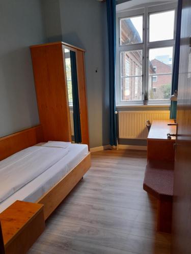 a bedroom with a bed and a large window at Hotel Pelli Hof Rendsburg by Tulip Inn in Rendsburg