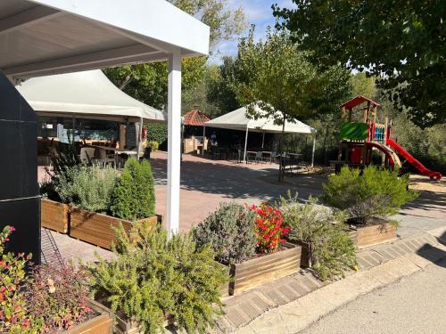 a garden center with plants and a playground at Camping Bungalow el Llac de Banyoles in Porqueres