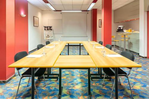 une salle de conférence avec une longue table et des chaises dans l'établissement Mercure Millau, à Millau
