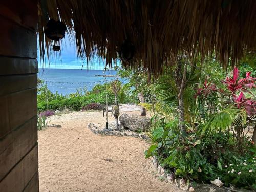 a view of the beach from a straw hut at Little Bay Bungalow in Little Bay