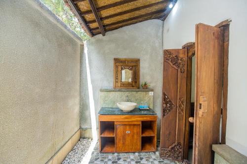 a small bathroom with a sink and a mirror at Tropical Garden by TANIS in Nusa Lembongan