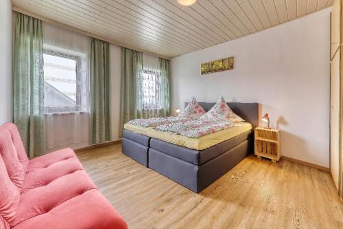 ein Schlafzimmer mit einem Bett und einem Sofa in einem Zimmer in der Unterkunft Ferienhof Guglhupf in Sankt Oswald