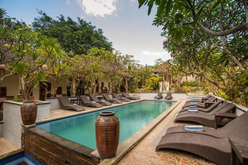 einen Pool mit Liegestühlen und ein Resort in der Unterkunft Tropical Garden by TANIS in Nusa Lembongan