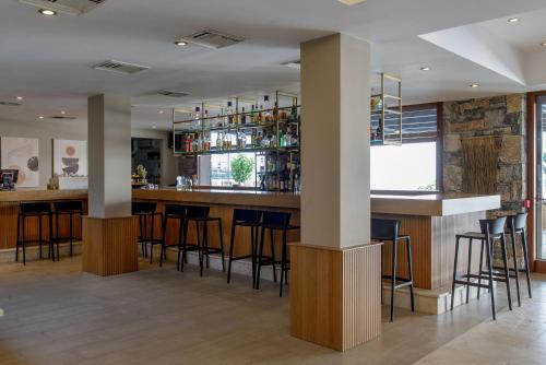a bar in a restaurant with bar stools at Blue Sea Beach Affiliated By Melia in Stalida