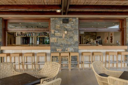 a restaurant with a stone bar with a table and chairs at Blue Sea Beach Affiliated By Melia in Stalida