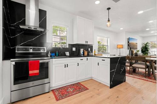 a kitchen with white cabinets and black appliances at Spacious Family 3BR Near Wynwood and Beach in Miami