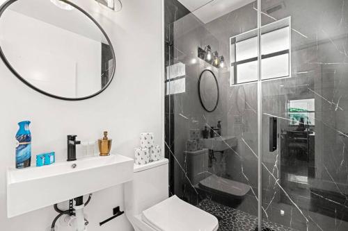 a bathroom with a sink and a mirror and a shower at Spacious Family 3BR Near Wynwood and Beach in Miami