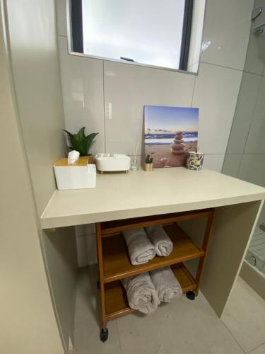 y baño con encimera con lavamanos y toallas. en Marina Bay Apartment, en Durban