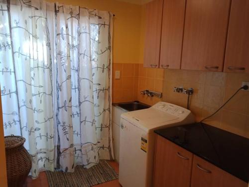 a kitchen with a refrigerator and a shower curtain at Amazing Perfect Family Home - GC Beach location in Gold Coast
